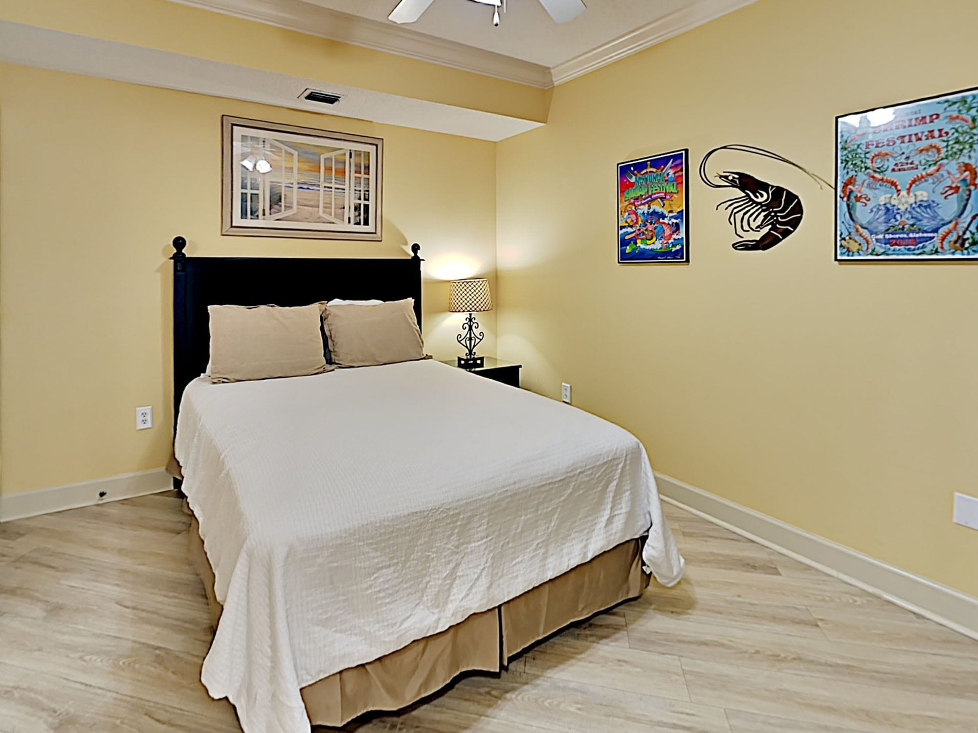 Una camera da letto con un letto, un comodino, una lampada e decorazioni alle pareti.