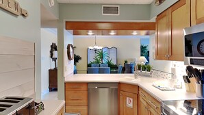 A modern kitchen with wooden cabinets, a stainless steel dishwasher, and a built-in oven. - Island Echos #3K by Southern Vacation Rentals (Fort Walton Beach)