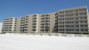 A multi-story hotel with balconies, located near a sandy area. - Island Echos #3K by Southern Vacation Rentals (Fort Walton Beach)