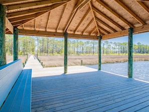 Enjoy a serene view of the surrounding landscape from this expansive deck, featuring a body of water and forested area.