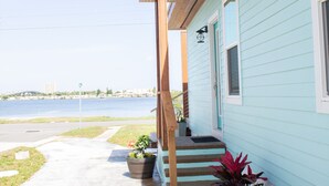 A light blue building with a wooden porch and steps leading to the entrance.