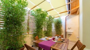 A wooden table with chairs, a purple tablecloth, and a basket of bread. - Industrial design loft with outdoor living terrace (Florence)