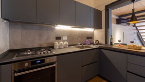 A modern kitchen with a built-in oven, a gas stove, a sink, and a digital clock. - Industrial design loft with outdoor living terrace (Florence)