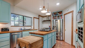 A modern kitchen with light blue cabinets, stainless steel appliances, and a wooden island. - Ask for 20% Off, Cozy Home, Riverfront, Nature (New Braunfels)