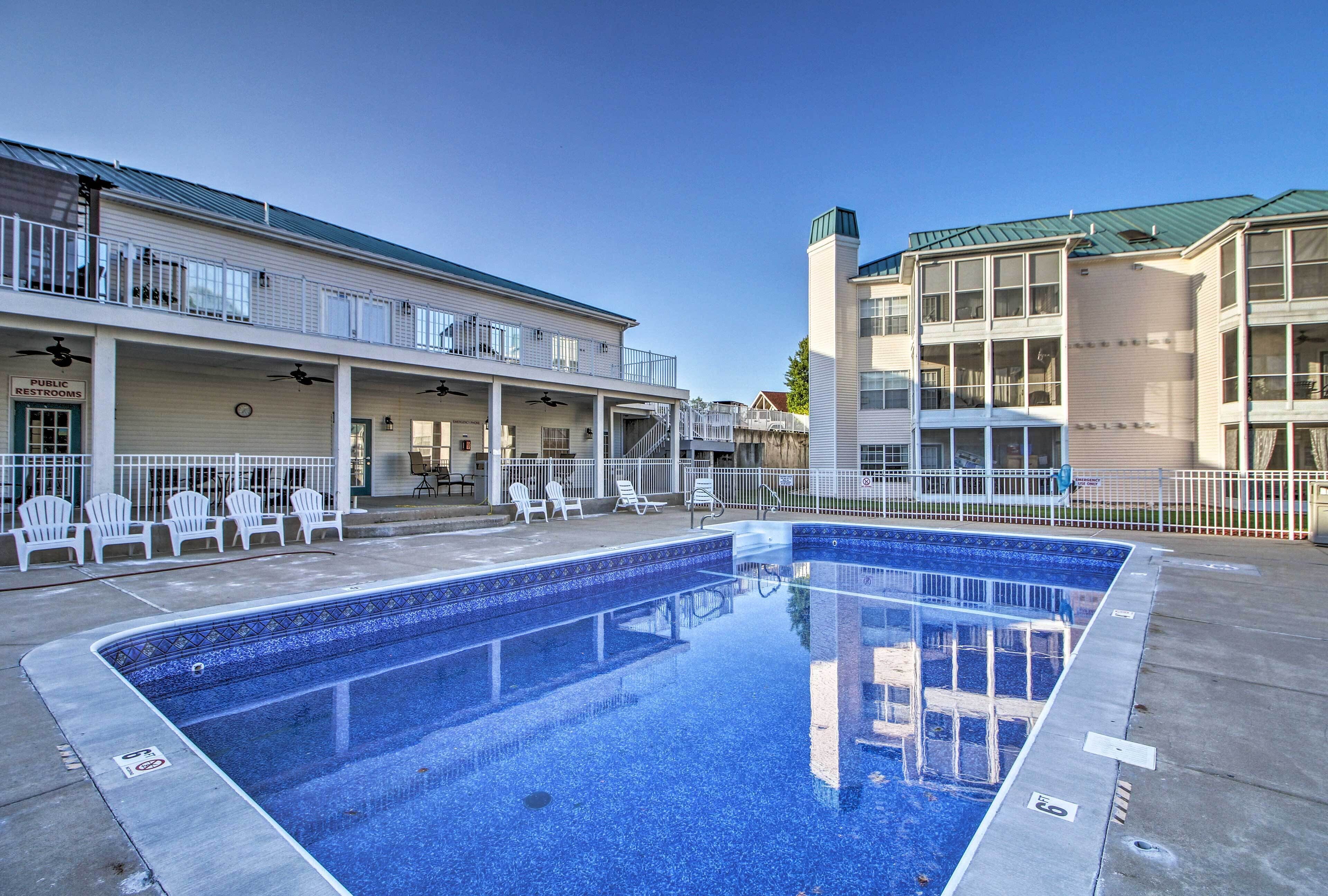 A swimming pool area with lounge chairs and a covered seating area.
