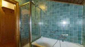 A bathroom with a glass shower enclosure, a bathtub, and tiled walls. - Spazioso appartamento centralissimo con wi-fi. (Cortina d´Ampezzo)