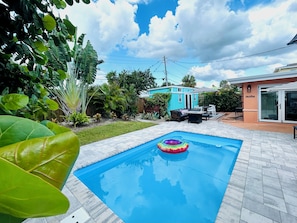 A swimming pool with a floating ring, surrounded by a patio area with outdoor furniture. -  FALL DISCOUNT! Tropical Beach Bungalow w/Private Saltwater Pool and Pool House (St. Pete Beach)
