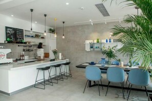 Une cuisine moderne dotée d’un coin bar, de tabourets de bar et d’une table à manger avec des chaises.