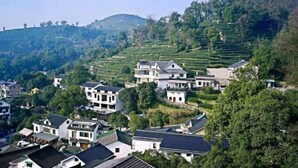 Ein Dorf an einem Hang mit terrassenförmig angelegten Feldern und traditionellen Häusern.