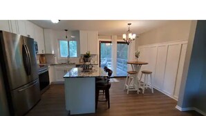 A kitchen with a central island, stainless steel appliances, and a view to the outdoors. - All you need for your home away from home in MN (Sauk Rapids)