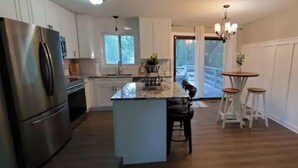 A kitchen with a central island, stainless steel appliances, and a view to the outdoors. - All you need for your home away from home in MN (Sauk Rapids)