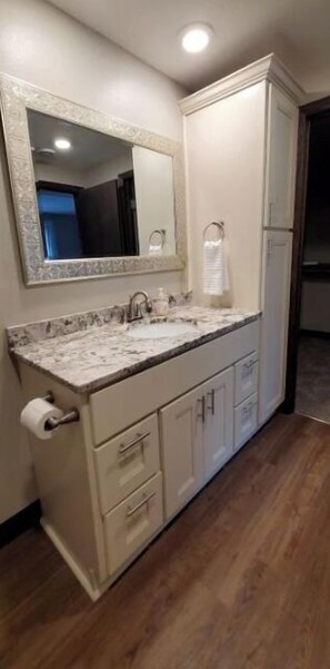 A bathroom with a marble sink, a large mirror, and a towel rack. - All you need for your home away from home in MN (Sauk Rapids)