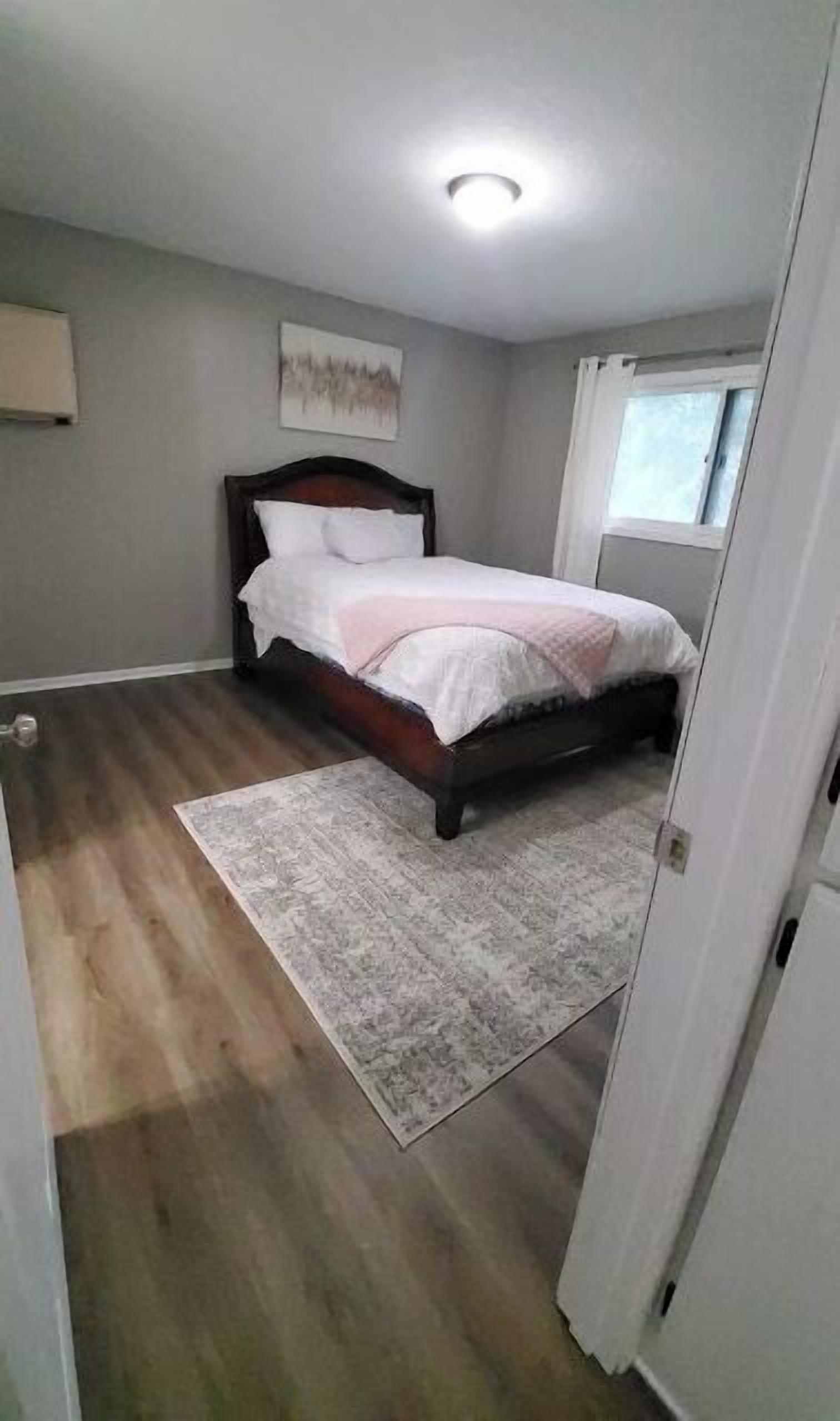 Un dormitorio con una cama, una ventana y una puerta.