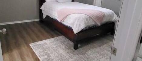Un dormitorio con una cama, una ventana y una puerta.