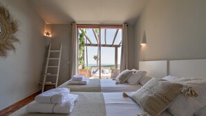 Habitación de hotel con dos camas, una escalera y vista al exterior.