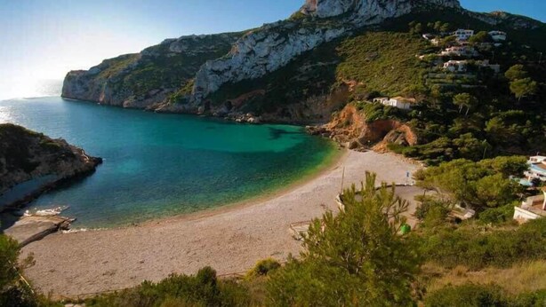 A coastal landscape with a beach, rocky cliffs, and houses on a hillside. - Son de Mar - By Almarina Villas (JÁVEA)