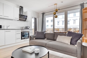 Enjoy a comfortable living space with a kitchen, sofa, and coffee table.