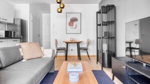 A modern living room with a sofa, coffee table, and dining area. - Sunny Brigittenau 1BR w/ Elevator & Storage, nr Augarten, by Blueground (Vienna)