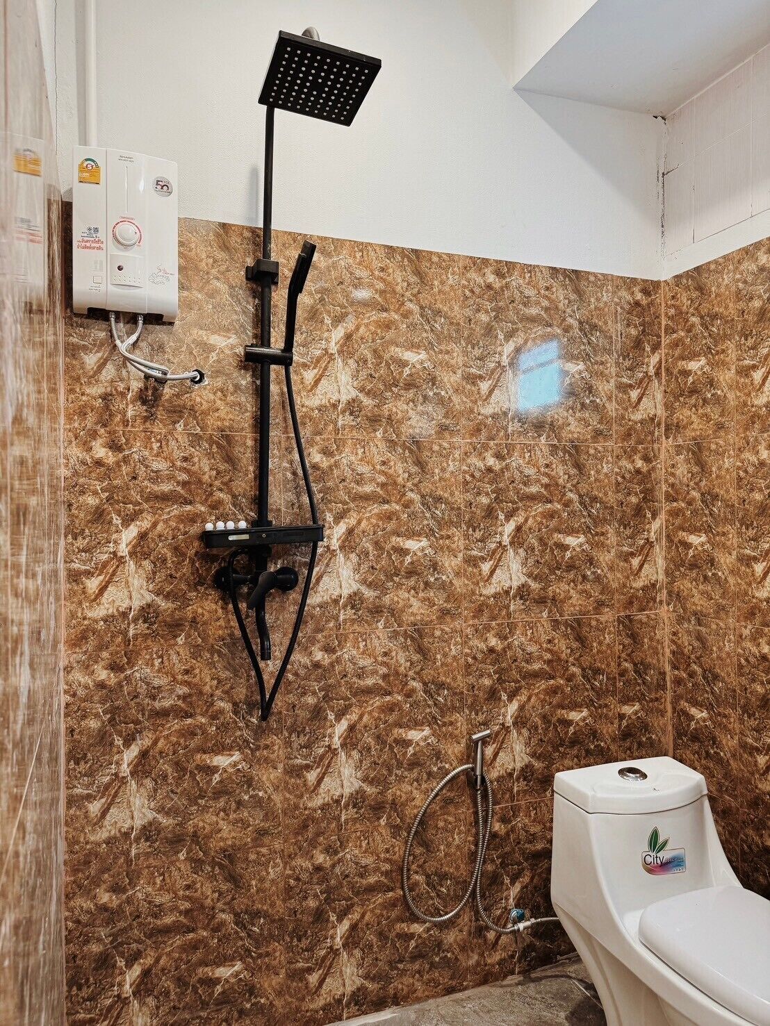 Un baño con ducha, inodoro y calentador de agua.