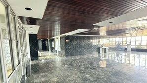 Un'ampia hall con pavimento in marmo lucido, ampie finestre e un moderno design del soffitto.