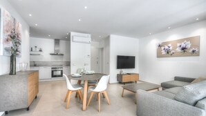 A modern living space with a dining area, kitchen, and a grey sofa. - Colinas - Ancor 0.3 POOL VIEW 1B (Arona)
