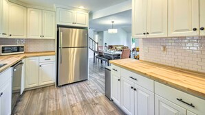 A modern kitchen with white cabinets, stainless steel appliances, and a wooden countertop. - Stunning Hood Canal Getaway w/ Private Deck! (Belfair)
