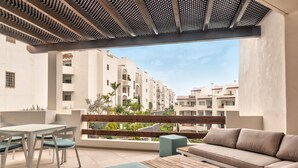 Un balcon avec une table, des chaises et un canapé.