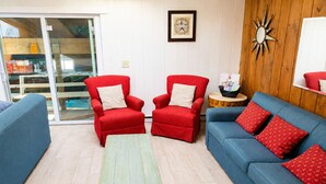 A living room with two red armchairs, a blue sofa, and a wooden coffee table. - Large North Conway Vacation Home Indoor Pool, Pool Table Sleeps 22 (Conway)