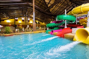 An indoor water park with multiple water slides and a pool.