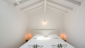 A bedroom with a large bed, two bedside tables, and a skylight.