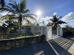 Enter a tranquil oasis through this secure gated entrance, surrounded by lush palm trees.