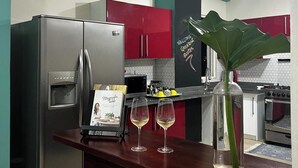 Cocina moderna con electrodomésticos de acero inoxidable, encimera de madera y un letrero de bienvenida.