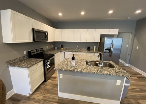 Kitchen features a microwave, refrigerator, and dishwasher, along with a center island and sink.