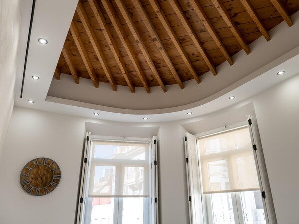 Une pièce dotée d’un plafond en bois, d’un éclairage encastré et de grandes fenêtres.