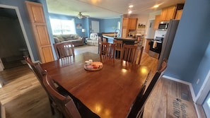 A dining area with a wooden table, chairs, and a tray with food.