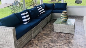 Een overdekt terrasgedeelte met een modulaire bank en een bijzettafeltje.