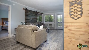 Un salon avec un canapé beige, une table basse et un élément décoratif en bois sur le mur.