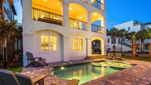 A multi-story building with a swimming pool, outdoor seating, and a well-lit balcony. - VILLA ST MARIE: Amazing Water Views ~ Brand NEW Pool! ~  5 Master Suites ~ 1 Row from Private Beach (Destin)