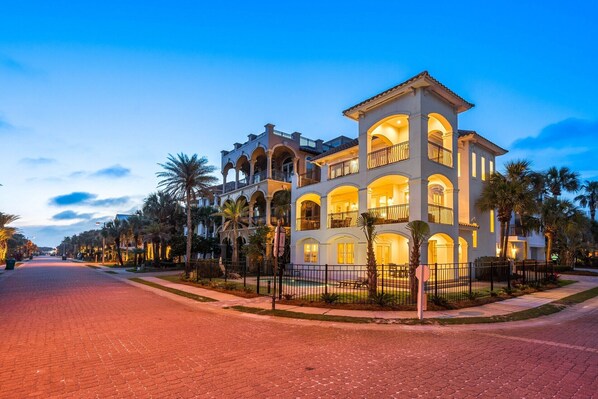 A multi-story hotel with a central courtyard, balconies, and palm trees.
