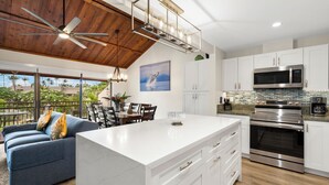 Una cocina moderna con armarios blancos, electrodomésticos de acero inoxidable y una isla grande.