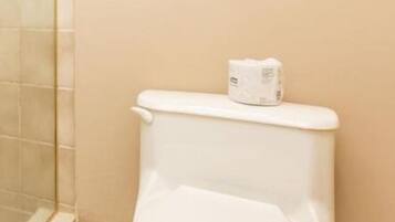 A white toilet in a bathroom with beige walls and tiled flooring.
