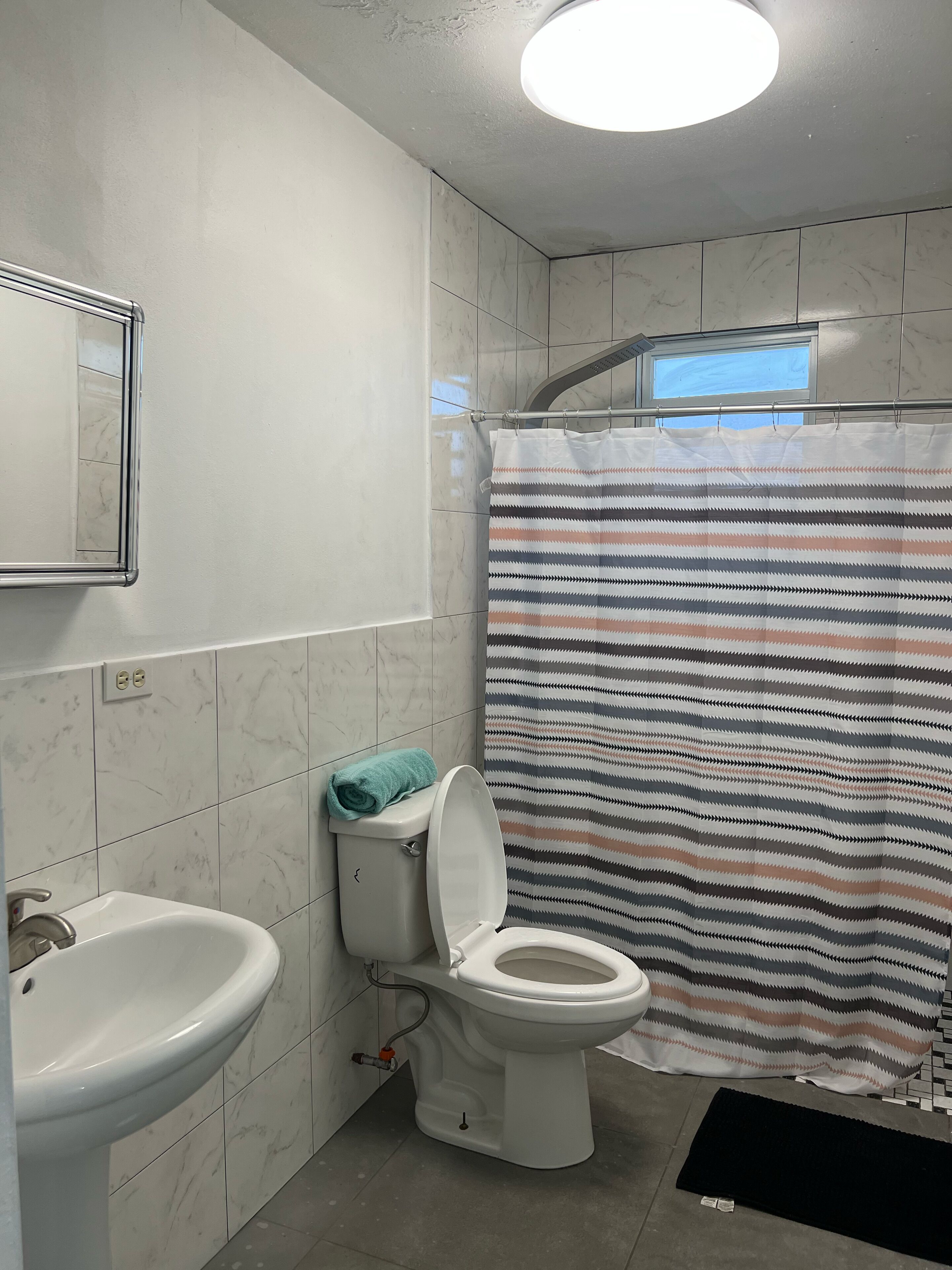 Ein Badezimmer mit Toilette, Waschbecken und Duschvorhang.