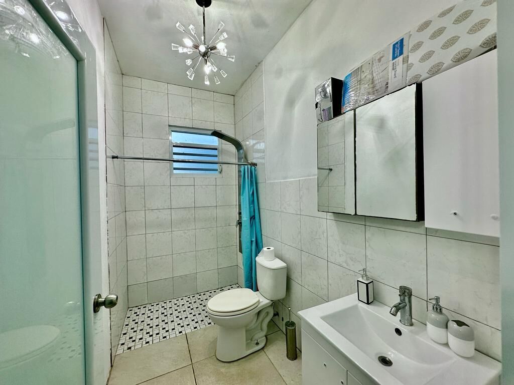 A bathroom with a toilet, sink, and shower area.
