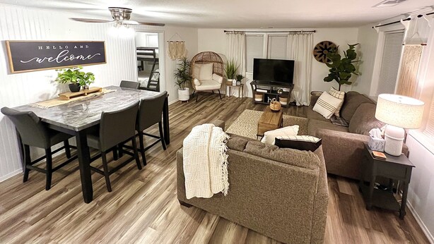 Een moderne woonkamer met een eetgedeelte, een televisie en een gezellige zithoek.