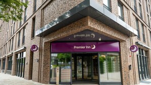 A brick building with a glass entrance and a purple awning labeled 'Premier Inn.' - Premier Inn Hamburg City Klostertor (Hamburg)