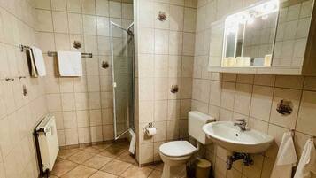 Un baño con inodoro, lavabo y ducha.