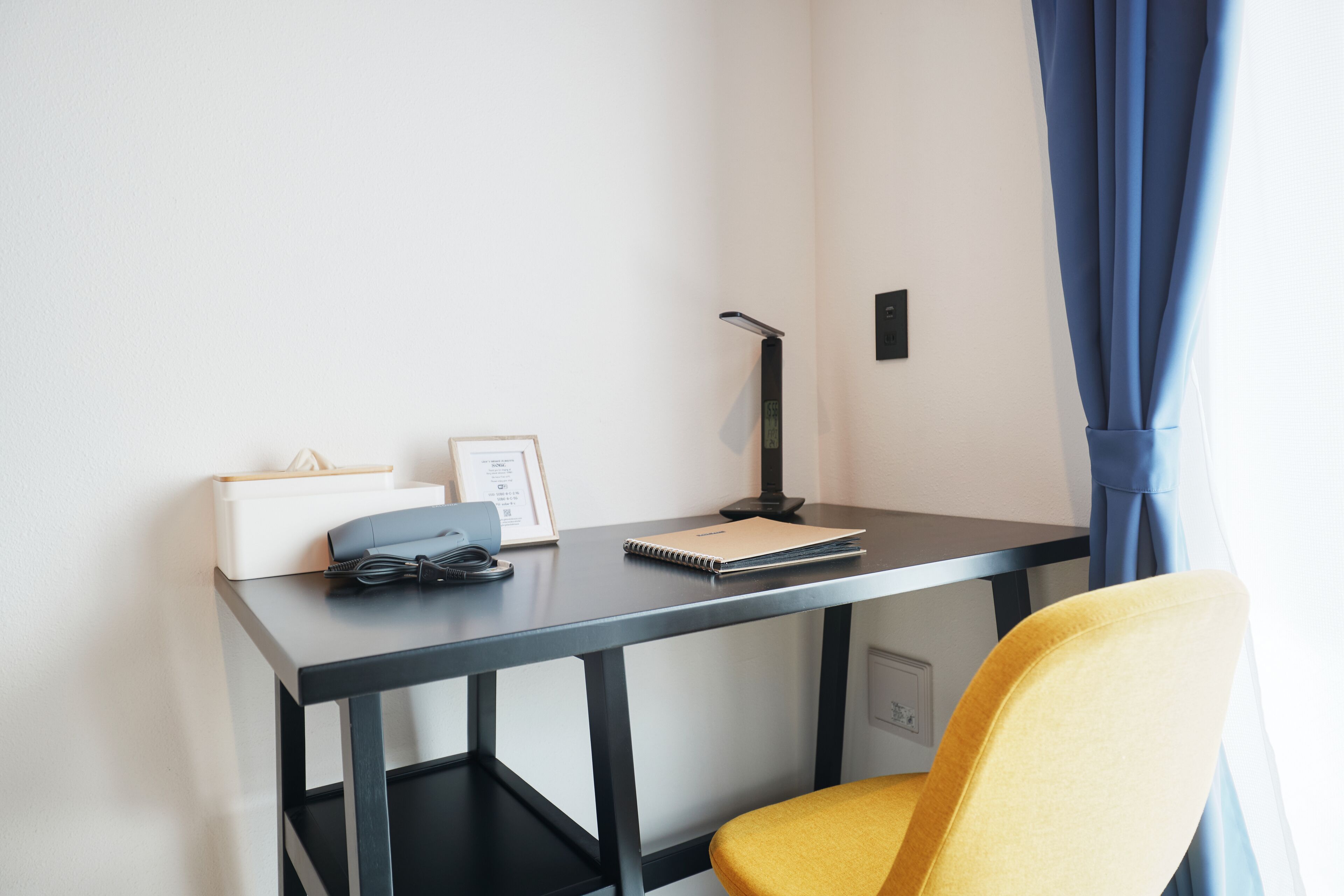 Une chambre moderne équipée d’un bureau, d’une chaise et d’une fenêtre avec des rideaux.