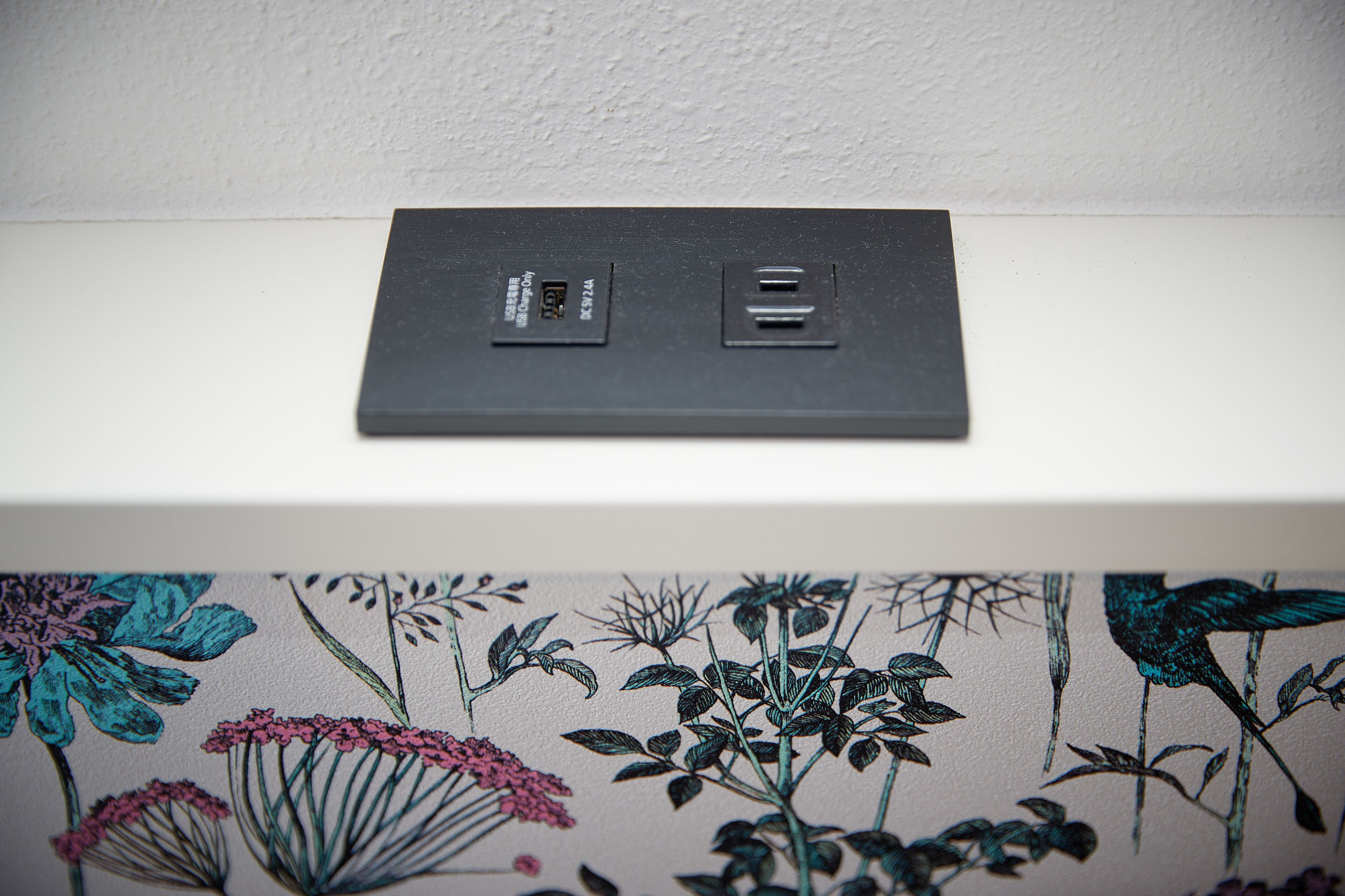 A black power strip with two USB ports and a label on a white surface.