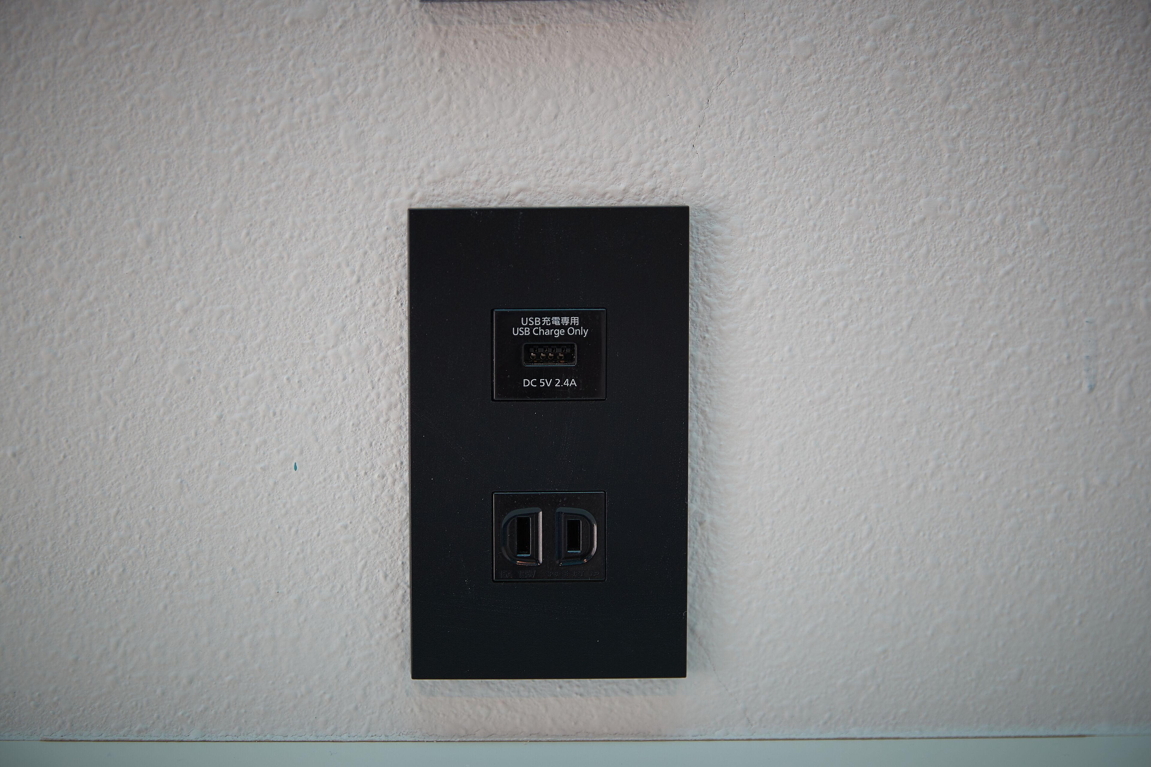 A black electrical outlet with a USB charging symbol and a label indicating it is USB charge only.