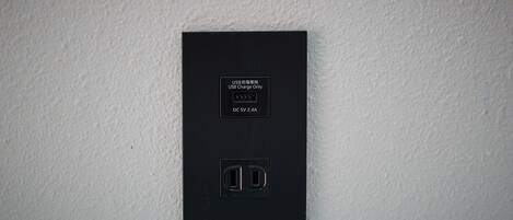 A black electrical outlet with a USB charging symbol and a label indicating it is USB charge only.